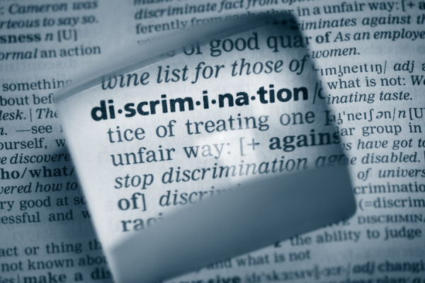 A dictionary with the word "discrimination" magnified and part of the definition shown in black and white